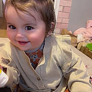 Syanna a rejoint le concours — aidez-le/la à gagner de superbes lots ! toddler, child, smile, indoor, hair_bows, pigtails, cardigan, patterned_clothing, face, hand, hairbrush, furniture, cozy, happy, cute, person, baby, home, sitting, playful