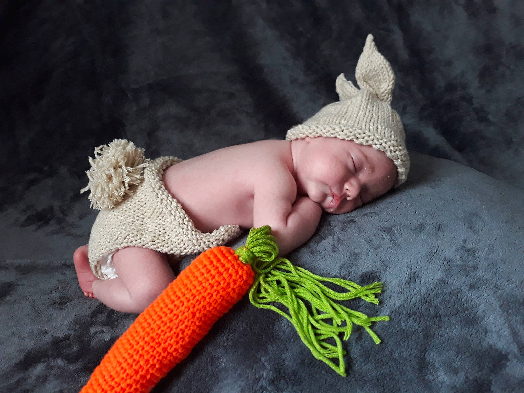 Noé participe au concours pour gagner de l'argent avec cette photo : baby, carrot, child, crochet, grass, hand, headgear, headwear, knitting, person, photography, plant, toddler, vegetable