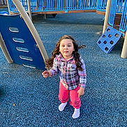 Callie joined the competition — help win amazing prizes! child, playground, blue, curly_hair, plaid_shirt, pink_pants, socks, outdoor, play_equipment, climbing_structure, rubber_flooring, daylight, person, recreation, fun, young, casual_clothing, looking_up, park, happy