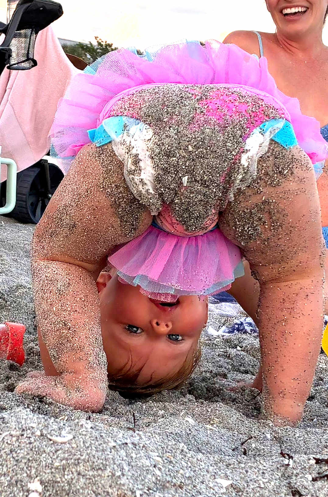 Ella joined the competition — help win amazing prizes! toddler, child, beach, sand, pink_tutu, upside_down, smiling, playful, happy, barefoot, person, summer, fun, cute, outdoor, family, baby, clothing, joy, sunlight
