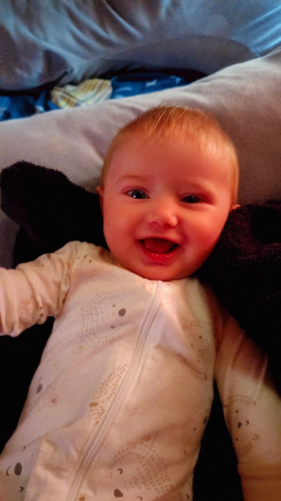 Dilylah is registered to the contest to win money with this photo: baby, smiling, infant, onesie, cute, happy, child, face, portrait, lying_down, cozy, soft, patterned_clothing, young_child, indoors, head, cheerful, skin, baby_clothes, closeup