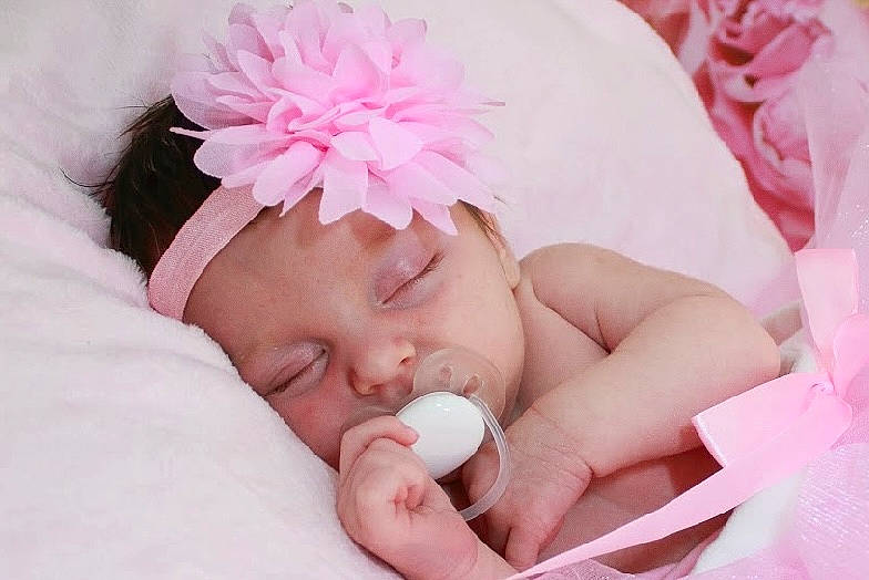 Lou participe au concours pour gagner de l'argent avec cette photo : baby, baby_sleeping, baby_toddler_clothing, cap, cheek, comfort, eyebrow, finger, flower, hand, head, headgear, headpiece, headwear, lip, nail, person, petal, pink, skin
