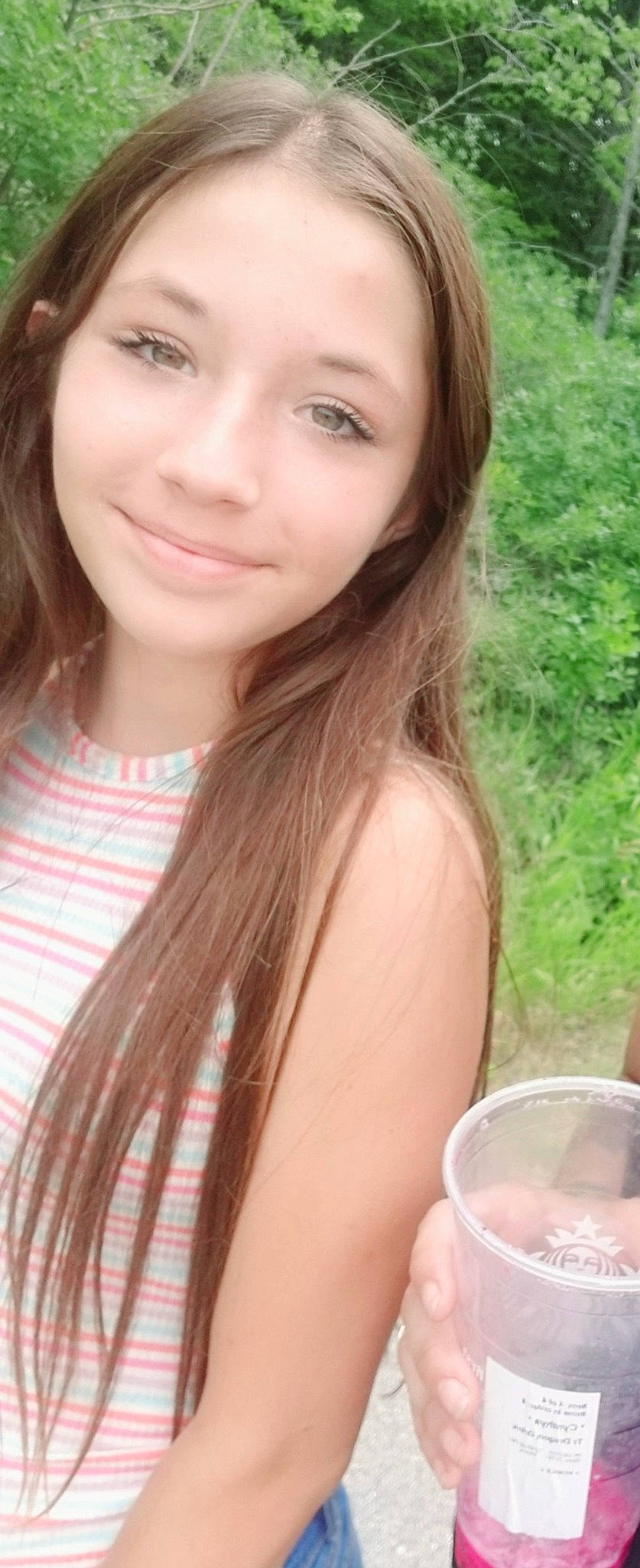 Elora joined the competition — help win amazing prizes! bangs, black_hair, blond, brown_hair, cup, drinking, drinkware, eyebrow, eyelash, face, grass, hairstyle, happy, joy, layered_hair, lip, long_hair, person, skin, smile