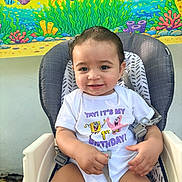 Jay joined the competition — help win amazing prizes! baby, child, high_chair, onesie, birthday, smile, face, person, seatbelt, cartoon_characters, spongebob, party, celebration, colorful, underwater_theme, decorations, cheerful, cute, indoors, young_child