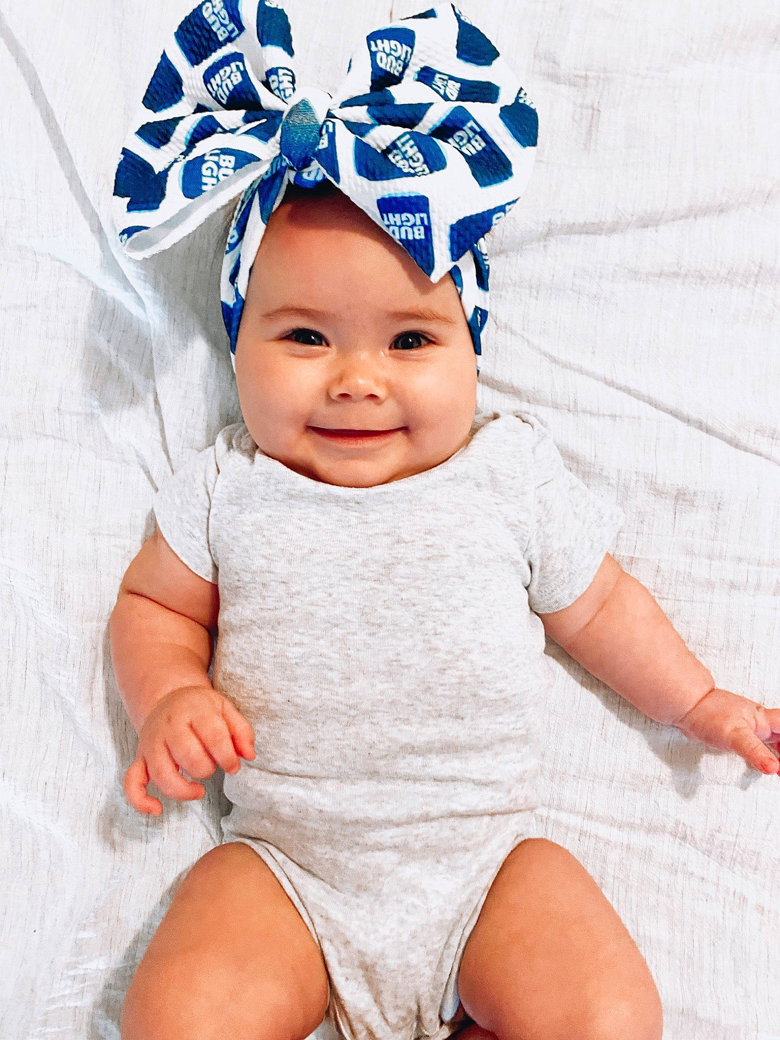 Leighton is registered to the contest to win money with this photo: baby, baby_sleeping, baby_toddler_clothing, blue, cap, comfort, eye, happy, hat, head, headgear, headwear, human_body, joy, linens, person, pink, skin, sleeve, smile