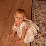 toddler, child, white_dress, crawling, wooden_floor, rug, indoor, curious, baby, person, flooring, patterned_rug, young_child, portrait, cute, elegant, feather, looking_up, small_child, home