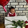Kyrie joined the competition — help win amazing prizes! toddler, smiling, child, red_vest, white_shirt, balloons, roses, table, brick_wall, wooden_floor, happy, celebration, indoors, plant, flower, person, portrait, cute, decor, joy