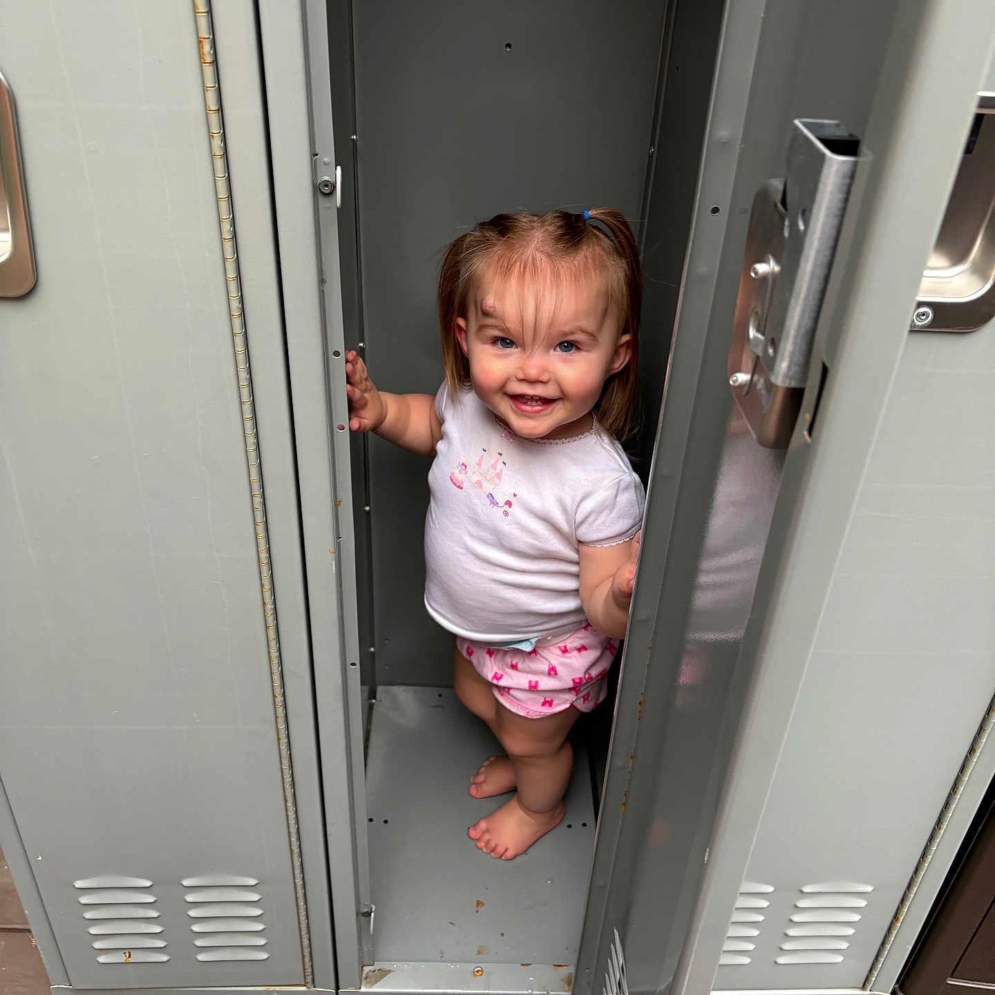 Wrenley joined the competition — help win amazing prizes! barefoot, child, clothing, cute, door, feet, floor, hair, happy, indoor, locker, metal, person, pigtails, playful, shirt, shorts, smile, standing, toddler