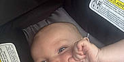 John is registered to the contest to win money with this photo: baby, child, car_seat, smile, hand, fingers, face, infant, seatbelt, happiness, cute, closeup, person, safety, young_child, skin, head, expression, car, straps