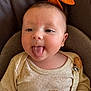 Maël participe au concours pour gagner de l'argent avec cette photo : baby, infant, tongue_out, cute, playful, beige_clothing, wooden_clip, plush_toy, cushion, close_up, face, head, person, child, smile, soft_lighting, indoors, portrait, young, apparel