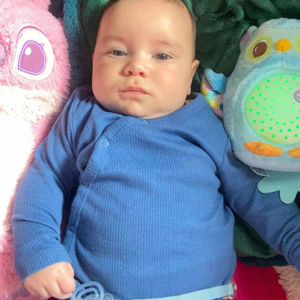 Milhan a rejoint le concours — aidez-le/la à gagner de superbes lots ! baby, blue_onesie, plush_toy, pink_toy, blue_toy, blanket, infant, lying_down, indoor, cute, child, pacifier, soft_toys, cozy, portrait, one_person, young_child, baby_clothes, face, expression