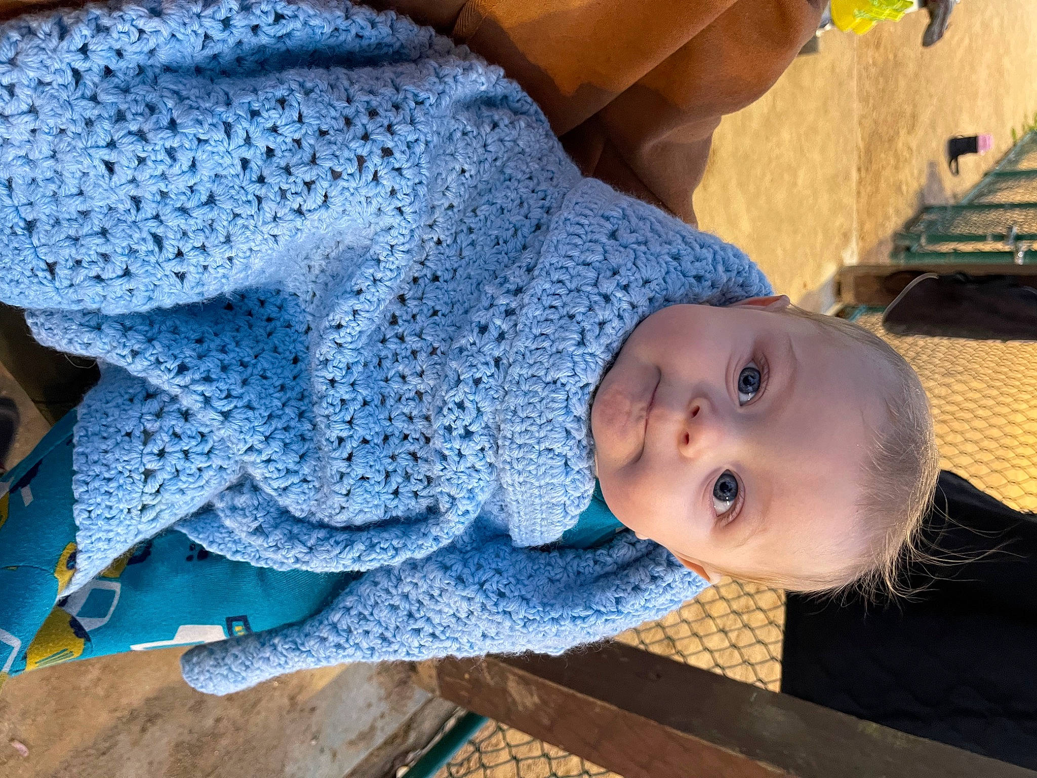 Damien is registered to the contest to win money with this photo: baby, baby_products, baby_safety, baby_toddler_clothing, blue, child, comfort, electric_blue, fashion_accessory, fun, hat, headgear, pattern, person, sitting, sleeve, smile, toddler, tree, wood