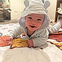 baby, smiling, hooded_outfit, bear_ears, blanket, indoor, carpet, happy, child, portrait, cute, infant, crawling, clothing, person, face, soft_lighting, room, toy, furniture