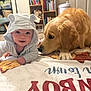 Walker Lee joined the competition — help win amazing prizes! baby, hoodie, bear_ears, blanket, dog, golden_retriever, pet, smiling, indoor, carpet, bookshelf, books, furniture, room, cute, child, animal, friendship, cozy, portrait