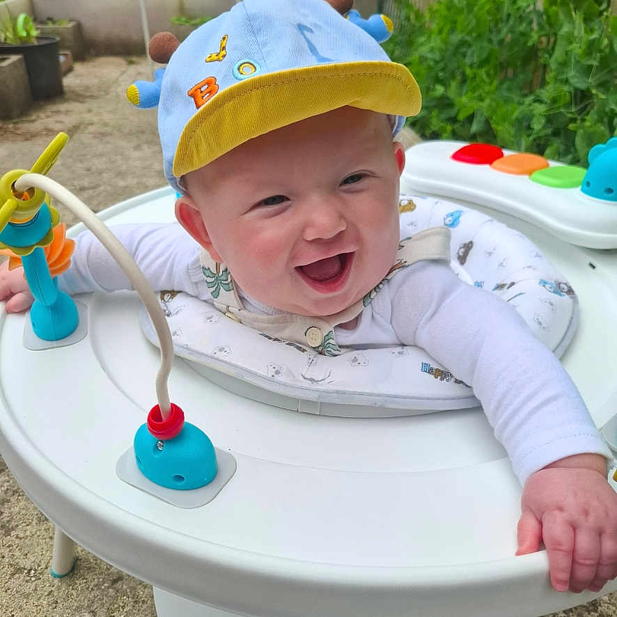 Ayden a rejoint le concours — aidez-le/la à gagner de superbes lots ! activity_center, baby, cap, child, clothing, colorful, cute, face, garden, greenery, hand, happy, infant, nature, outdoor, person, play, seat, smiling, toy