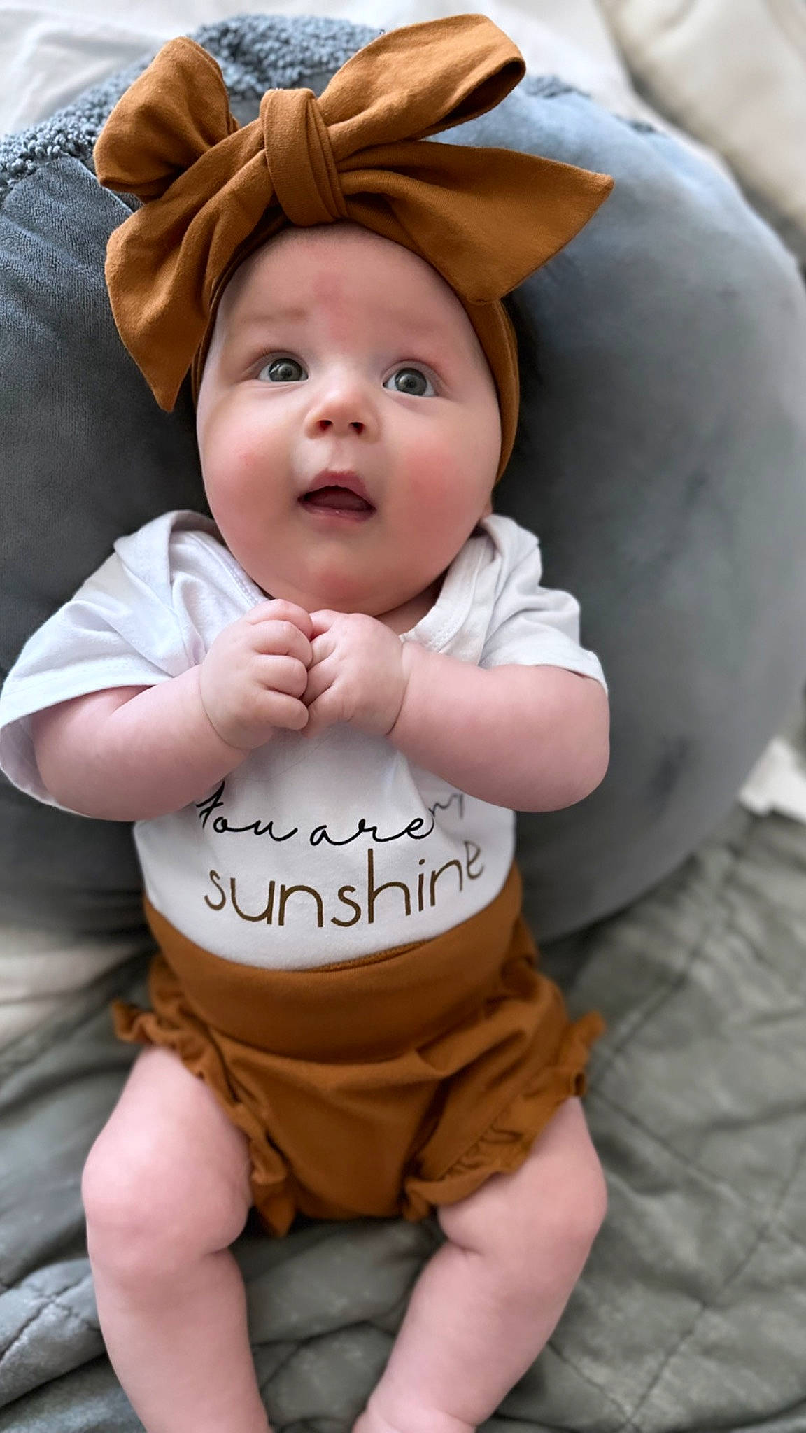 Georgia is registered to the contest to win money with this photo: baby, baby_toddler_clothing, cheek, child, facial_expression, finger, gesture, happy, headwear, human, orange, people, person, pink, plant, product, skin, sleeve, smile, textile