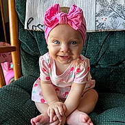 Braelynn joined the competition — help win amazing prizes! baby, barefoot, blue_eyes, child, close_up, cross_legged, cute, dress, face, green_chair, happy, headband, indoors, infant, pink_bow, portrait, sitting, small_hands, smiling, young