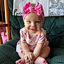 baby, child, smiling, pink_bow, headband, blue_eyes, sitting, green_chair, cross_legged, cute, infant, dress, happy, indoors, portrait, small_hands, barefoot, close_up, face, young