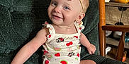 Braelynn is registered to the contest to win money with this photo: baby, barefoot, child, cushioned_chair, cute, earrings, flowers, green_chair, happy, home_decor, indoor, infant, minnie_mouse_print, onesie, portrait, red_bow, sitting, smile, table, wooden_chair