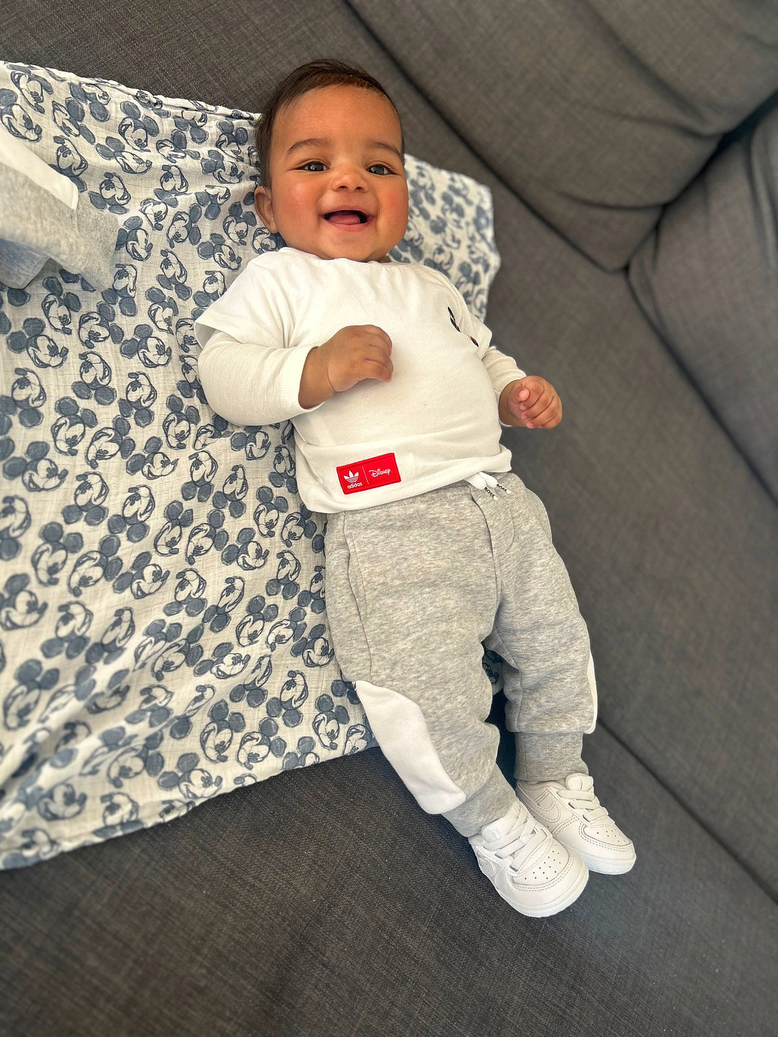 Leeroy participe au concours pour gagner de l'argent avec cette photo : baby, baby_products, baby_sleeping, baby_toddler_clothing, child, comfort, couch, face, flooring, happy, human_body, linens, pattern, person, sitting, sleeve, smile, sportswear, t_shirt, toddler