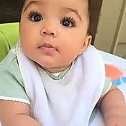 Lavinia joined the competition — help win amazing prizes! baby, bib, child, clothing, curly_hair, cute, expression, eyes, face, hand, high_chair, indoor, infant, person, portrait, sitting, skin, table, toy, young