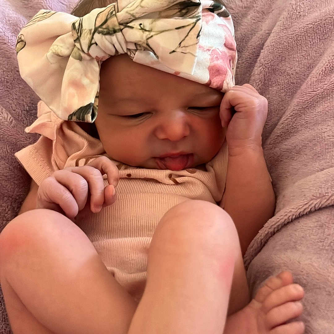 Isabella joined the competition — help win amazing prizes! baby, bed, blanket, bodypart, bonnet, cap, clothing, face, finger, furniture, hand, happy, hat, head, newborn, person, photography, portrait, sleeping, smile