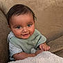 baby, blanket, child, clothing, couch, cozy, cute, face, hand, happy, indoors, infant, person, portrait, seated, smiling, soft, texture, warm, young