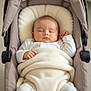 baby, sleeping, blanket, stroller, infant, cozy, white_clothing, peaceful, cushion, child, newborn, indoors, soft_lighting, resting, cute, portrait, small_hands, wrapped, head_support, baby_care