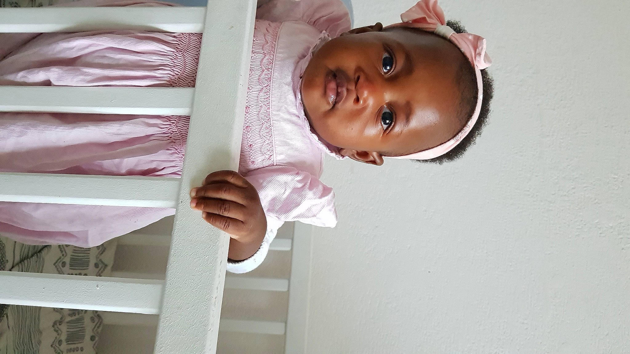 Hawa a rejoint le concours — aidez-le/la à gagner de superbes lots ! baby, baby_toddler_clothing, child, comfort, eye, eyelash, gesture, happy, hat, head, linens, magenta, person, room, sleeve, smile, thumb, toddler, white, window