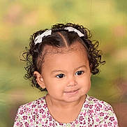 Camila is registered to the contest to win money with this photo: child, toddler, smile, curly_hair, hair_bows, floral_dress, portrait, face, cute, earrings, innocence, soft_lighting, studio_photo, background_blur, young_girl, happy, close_up, person, fashion, baby