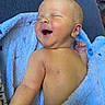 baby, infant, smiling, laughing, blue_blanket, soft_texture, skin, face, closed_eyes, happy, lying_down, couch, arm, hand, newborn, cute, indoors, person, child, portrait