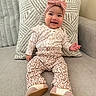 baby, child, smiling, sitting, portrait, indoor, couch, sofa, pillow, blanket, bow_headband, leopard_print, outfit, shoes, fashion, happy, infant, living_room, cozy, photography
