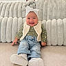 Samantha joined the competition — help win amazing prizes! baby, child, smiling, portrait, sitting, indoors, fashion, headband, bow, floral_outfit, vest, jeans, sneakers, blanket, couch, carpet, window_blinds, home, happy, cute