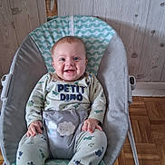 Ayden participe au concours pour gagner de l'argent avec cette photo : baby, baby_rocker, child, clothing, comfort, cushion, dinosaur_print, footwear, happy, indoor, infant, mirror, pajamas, person, portrait, reflection, seat, smiling, wood_floor, wood_paneling