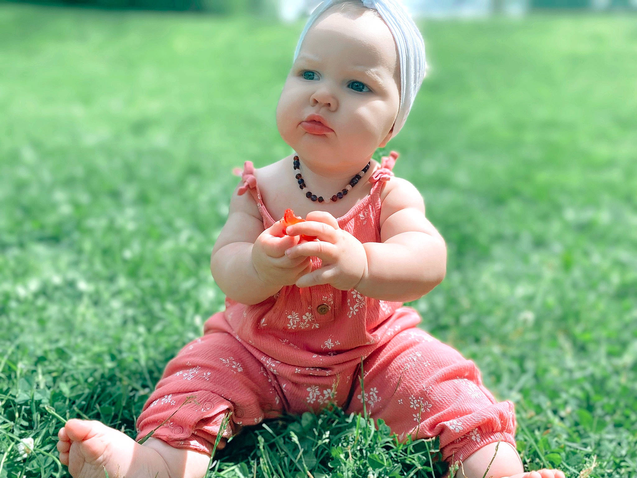 Freyja is registered to the contest to win money with this photo: baby, baby_toddler_clothing, cheek, child, finger, fun, grass, grass_family, grassland, green, groundcover, happy, headwear, lawn, meadow, people_in_nature, person, photograph, pink, plant