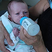 Eden participe au concours pour gagner de l'argent avec cette photo : baby, infant, bottle, feeding, towel, hand, adult, person, closeup, expression, indoor, newborn, care, nurture, clothing, blanket, skin, face, holding, feedingtime