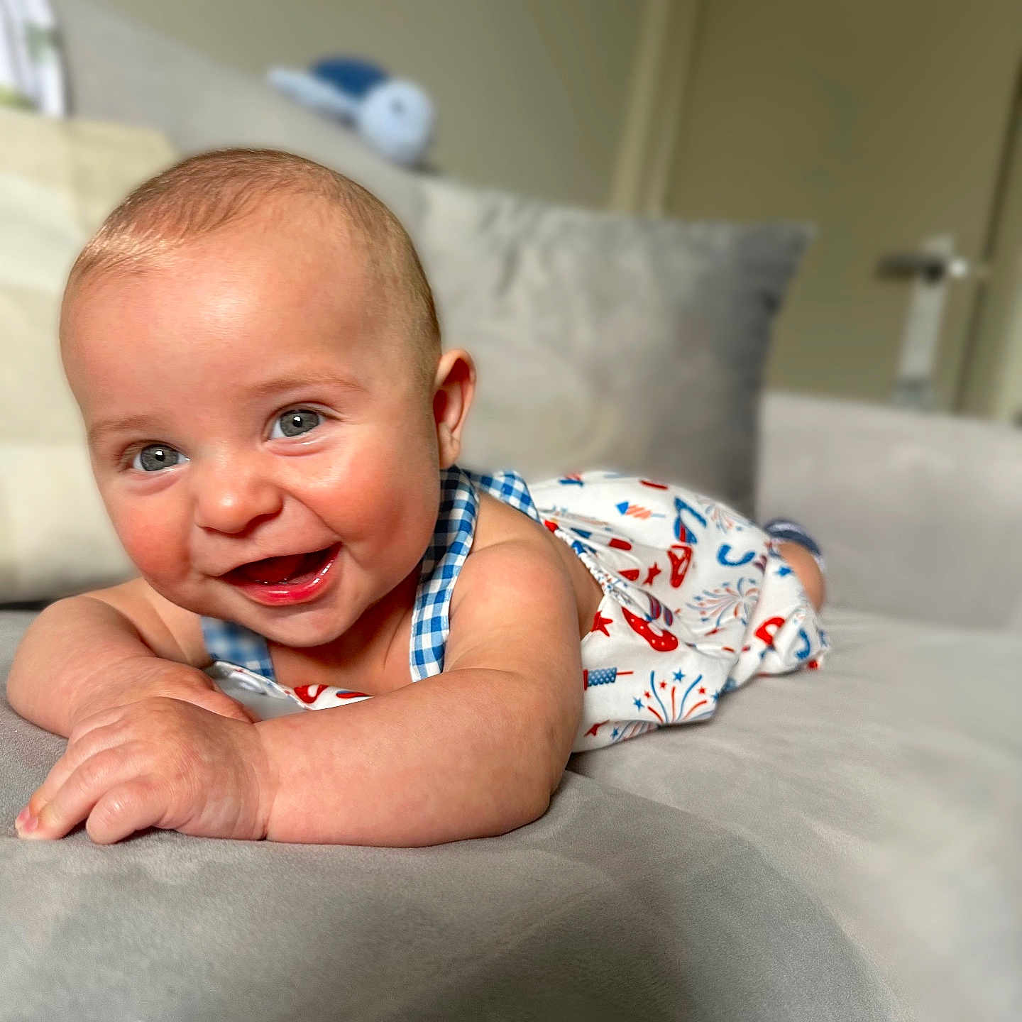 Asher joined the competition — help win amazing prizes! arm, baby, blue_eyes, blurred_background, cheerful, child, closeup, couch, cute, face, happy, indoor, infant, lying_down, patterned_clothing, portrait, skin, smiling, soft_furniture, toddler