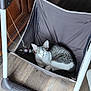 cat, sleeping, hammock, indoor, wooden_floor, toy, furniture, pet, resting, white, gray, striped, fabric, metal_frame, cozy, domestic, animal, cute, relaxed, small