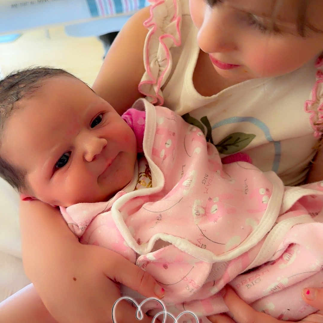 River joined the competition — help win amazing prizes! child, baby, newborn, holding, caring, love, tenderness, pink_blanket, cute, portrait, family, indoor, closeup, infant, smiling, sibling, soft_lighting, happy, human, people