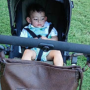 Muzammil joined the competition — help win amazing prizes! baby, bag, brown_bag, casual_clothing, child, cute, daylight, expression, grass, greenery, infant, outdoor, park, person, portrait, seatbelt, stroller, summer, toddler, young_child