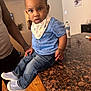 toddler, child, indoor, blue_shirt, denim_jeans, bib, knit_shoes, countertop, granite, adult, wooden_floor, painting, water_bottle, cabinet, person, home, curious, casual, portrait, expression