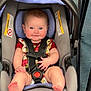 baby, infant, car_seat, child, smiling, blue_eyes, floral_outfit, bare_feet, seat_belt, cute, indoor, happy, chubby_cheeks, person, toddler, safety_harness, floor, playful, young_child, portrait