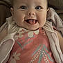 baby, infant, smiling, tongue_out, face, eyes, clothing, floral_pattern, blanket, cozy, cute, happy, portrait, child, indoors, soft_lighting, apparel, person, young, head