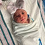 newborn, baby, hospital, blanket, swaddled, hat, bow, striped, infant, face, person, bed, bassinette, cute, wrapped, lying_down, sleepwear, newborn_baby, hospital_bed, child