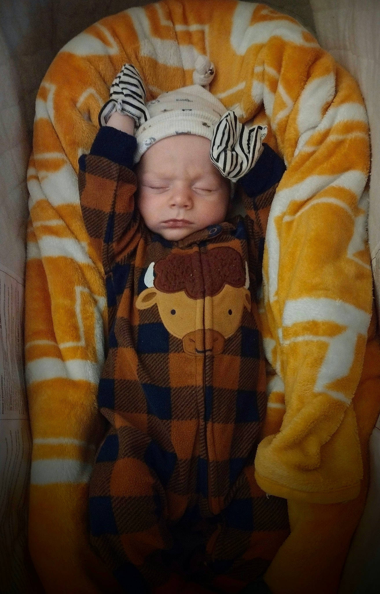 Jonah is registered to the contest to win money with this photo: baby, baby_sleeping, baby_toddler_clothing, beanie, child, collar, comfort, fur, headwear, knit_cap, linens, orange, outerwear, pattern, person, plaid, room, sleeve, tartan, textile