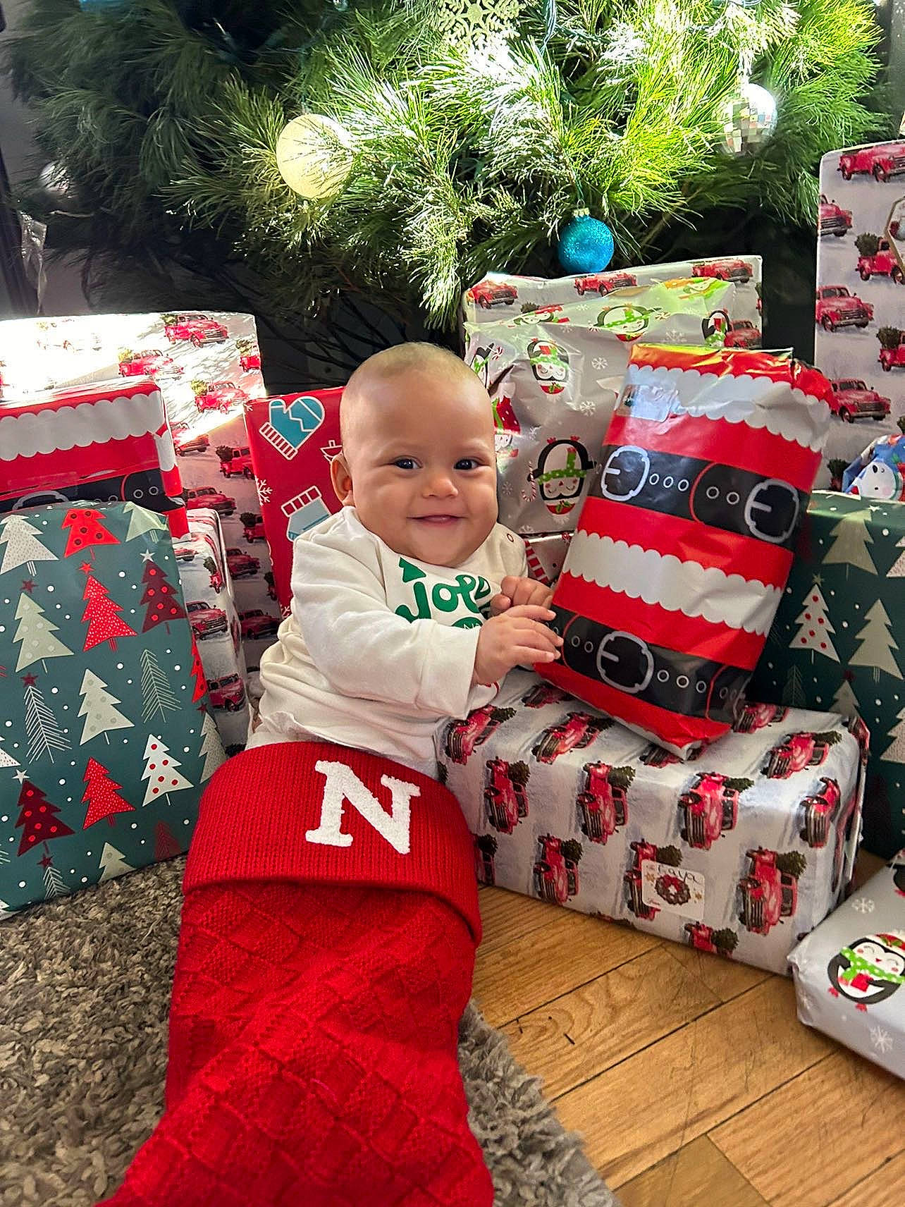 Nova joined the competition — help win amazing prizes! baby, baby_toddler_clothing, child, christmas, christmas_decoration, christmas_eve, christmas_ornament, event, happy, holiday, joy, lap, living_room, pattern, person, plant, red, sleeve, smile, t_shirt