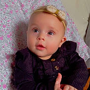 Mila joined the competition — help win amazing prizes! baby, infant, child, face, hands, headband, bow, clothing, pillow, pattern, floral, sitting, cute, portrait, indoors, curious, expression, soft_lighting, skin, young