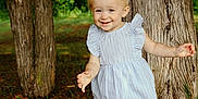 Aurora joined the competition — help win amazing prizes! toddler, child, smiling, barefoot, dress, pigtails, trees, forest, outdoor, grass, nature, sunlight, happy, young_child, person, standing, daylight, playful, cute, portrait