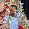 Tristan joined the competition — help win amazing prizes! child, boy, christmas_tree, ornament, red_star, white_shirt, green_bow_tie, holiday, festive, decorations, indoor, smiling, celebration, happy, cute, holiday_season, home, tree_lights, christmas, seasonal