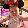 Yeimy participe au concours pour gagner de l'argent avec cette photo : baby, child, person, face, tongue, headwear, bow, mouse_ears, plush_toy, blanket, indoor, cute, smiling, playful, infant, clothing, sitting, soft_lighting, portrait, closeup